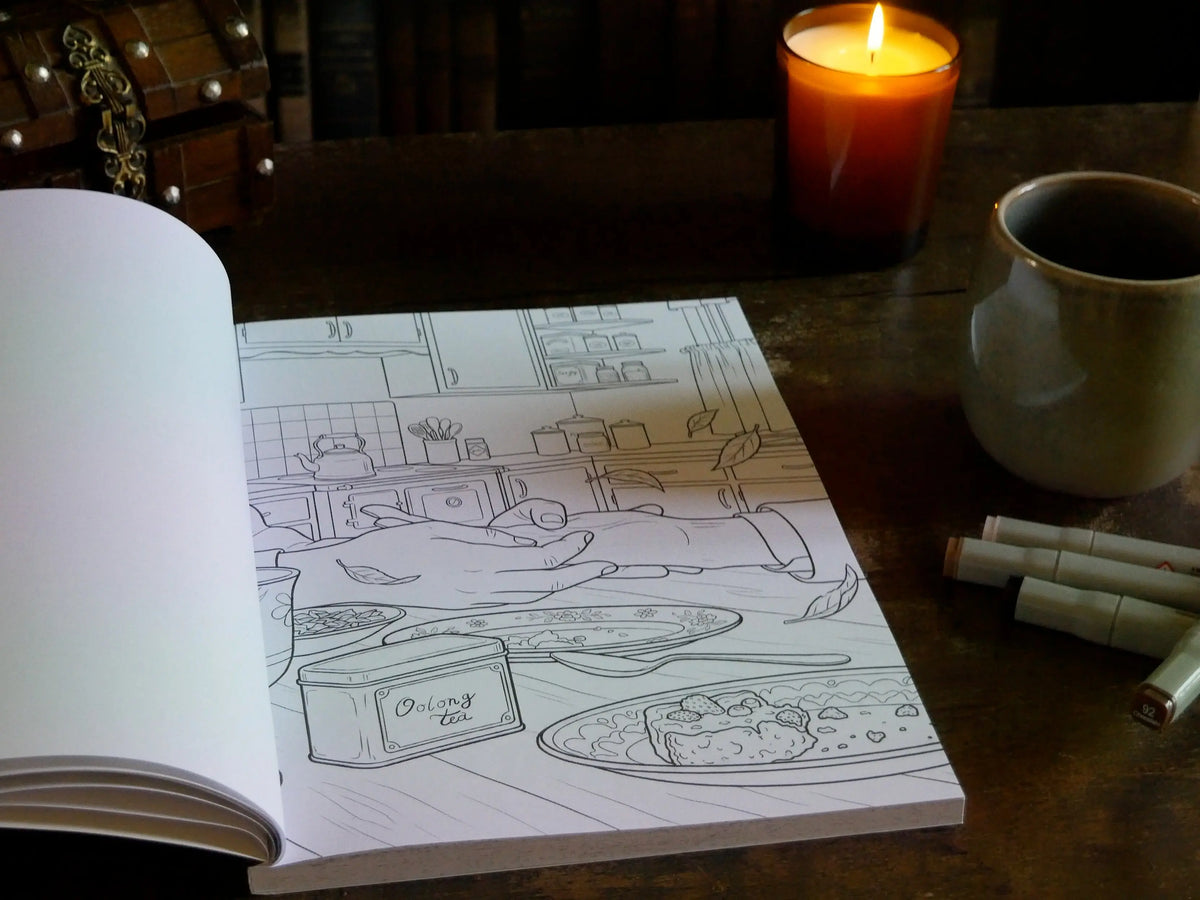 Vue d'ensemble du livre de coloriage ouvert sur la page Oolong tea, avec coffre en bois, bougie allumée, tasse et feutres